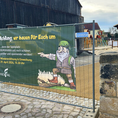 Noch wird am Spielplatz "Burgkania" gebaut. Aber die Eröffnung kommt bald, worauf das Banner schon einmal hinweist. 